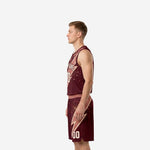 Side view of maroon sublimated basketball uniform set showing rose-gold armhole binding and lightning-bolt shorts panel detail