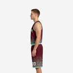 Side view of burgundy and mint custom basketball uniform set showing armhole binding, jersey hem diamond pattern fade, and matching shorts side panel