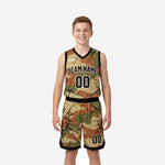Camo youth travel basketball uniforms in tan and olive with black cracked-earth overlay, jersey and shorts set, front view on youth boy model