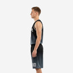 Side view of black and charcoal sleeveless basketball uniform showing armhole binding and shorts length on adult male player