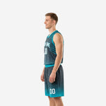 Side view of charcoal basketball uniform set showing teal armhole binding, starburst pattern on jersey, and teal diamond lattice hem on shorts