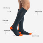 Pair of charcoal and blaze orange custom soccer socks laid side by side showing full over the calf length