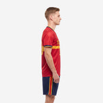 Custom red soccer uniform left side view showing V-neck trim cuff detail and Navy Blue shorts with red and gold side stripe