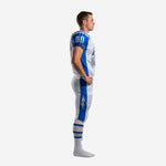Side view of white and royal blue custom American football uniform showing blue raglan sleeve and full-length blue side stripe on pants