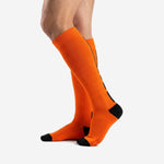 Custom Athletic Orange soccer socks left side view showing full length ribbed knit construction and black toe detail