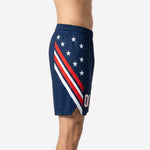 Navy basketball shorts with diagonal red and white stripe panel and white star scatter, elastic drawcord waistband and side hem split visible, side view