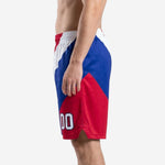 Side view of red and blue custom team basketball shorts showing elastic waistband, side split at hem, and diagonal color block pattern
