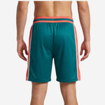Left-side view of teal custom basketball shorts showing coral-orange wide leg panel, white stripe trim, and straight-cut hem