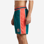 Right-side view of teal and coral-orange team basketball shorts with sublimated side panel and internal drawcord waistband