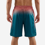 Back view of custom basketball shorts with logo showing full teal and coral honeycomb gradient fading from waistband to hem