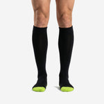 Custom black and green soccer socks front view showing jet black calf panel and neon green toe accent on adult male model