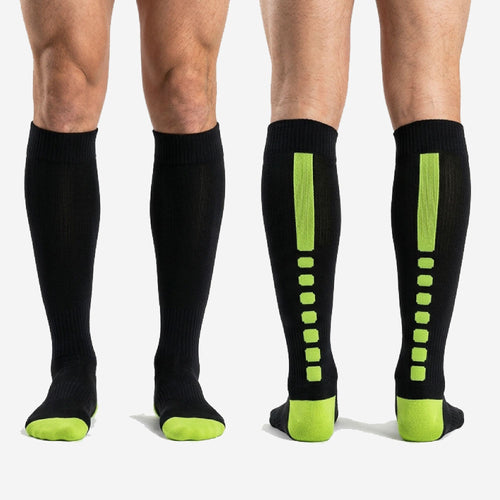 Custom black and green over the calf soccer socks worn by adult male showing full shin guard coverage and athletic fit