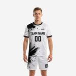 Custom black and white soccer uniform with splash and halftone print, crew neck jersey and matching shorts, front view on male model