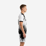 Custom black and white soccer uniform showing left-side splash panel and halftone dot pattern, side view on male model