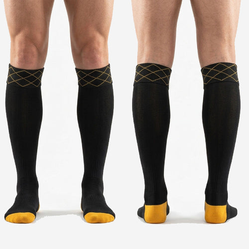 Full length profile of custom black and gold soccer socks showing knee high fit over shin guard position on adult male model