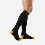 Custom black and gold soccer socks side view displaying Athletic Gold heel cap and toe cap with full knee high length on adult male model