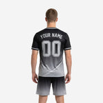 Custom black and gray soccer jersey close-up showing jet black to silver gradient and V-neck white trim