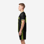 Custom black soccer uniform showing lime green triple side stripe on shorts, right side view on male model