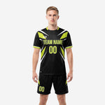 Custom all black soccer uniform with neon green geometric burst panels and matching shorts, front view on male model