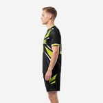 Custom black soccer uniform with neon green angular thigh panels on matching shorts, right side view on male model