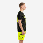 Custom black and yellow soccer uniform left side view displaying crew neckline trim and neon yellow cuff detail on male model