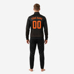 Close-up of custom black soccer tracksuit jacket with blaze orange chevron sublimation print and ribbed stand collar detail