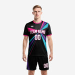 Custom black and pink soccer uniforms front view showing ray-burst print with team name and number on jet black jersey and matching shorts