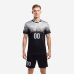 Custom black and white soccer uniforms with iridescent silver gradient jersey and matching black shorts, front view on male model