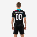 Close detail of slash graphic design on custom black soccer training jersey in turquoise hot pink and neon yellow
