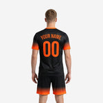 Detail view of custom black soccer jersey with Athletic Orange V-neck collar trim and full-dye sublimated gradient print