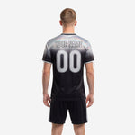 Close detail of custom black and white soccer jersey showing gradient sublimation print and crew neckline trim