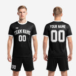 Full custom black and white soccer kit set showing jersey and matching shorts with white side stripe for club and school teams