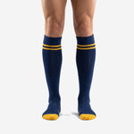 Custom blue and gold soccer socks in Navy Blue with Athletic Gold double-stripe bands, front view on male model