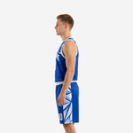 Side view of royal blue custom basketball uniform showing white armhole binding and geometric shard pattern on shorts side panel