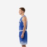 Side profile of royal blue sublimated basketball uniform showing halftone fade on jersey lower half and matching diamond-lattice shorts hem