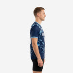 Full print blue soccer training jersey showing Ice Blue shattered-glass sublimation pattern across Navy Blue base, adult male model, left side view