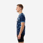 Mens custom blue soccer training jersey with Ice Blue V-neck trim and sleeve cuff detail, geometric shard print visible across back panel, right side view