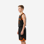 Side view of custom boys basketball uniforms showing black mesh jersey V-neck binding and matching black shorts with orange hem trim