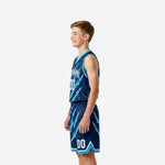 Matching youth basketball jersey and shorts navy and cyan side view showing V-neck binding, armhole edge, and shorts side split at hem