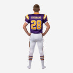 Right side view of custom kids football uniforms in purple and gold showing sleeve number placement and matching pant stripe detail