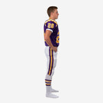 Side view of custom boys football uniforms showing purple jersey with short set-in sleeves, white cuffs with gold stripe, and white pants with double purple and gold side stripe