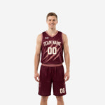 Custom burgundy basketball uniforms full set front view showing claw-mark graphic team name arc and cream block numbers on maroon jersey and shorts
