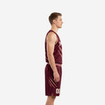 Side view of custom burgundy basketball uniform showing rose armhole binding claw-mark side panel and maroon shorts with drawcord waistband