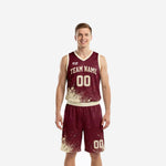 Custom burgundy basketball uniforms front view showing cream-gold splash pattern on jersey and matching shorts with arched team name and number