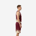 Side view of custom burgundy basketball uniform set showing cream-gold splash hem detail on sleeveless jersey and matching shorts