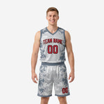 Custom camo basketball uniforms in grey digital camo with red arced team name and bold front number on adult male model, front view