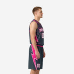 Charcoal and hot-pink sublimated basketball jersey and shorts showing pink side panel and lightning bolt on shorts leg - side view