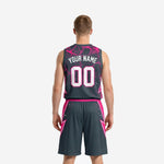 Opposite side view of charcoal and hot-pink basketball uniform showing side split hem on shorts and armhole binding detail