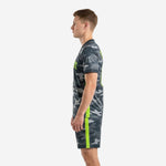 Custom charcoal camo grey soccer uniforms with neon green side stripe, right side view on male model