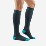 Custom charcoal and teal soccer socks side view displaying over the calf length and ribbed elastic cuff band